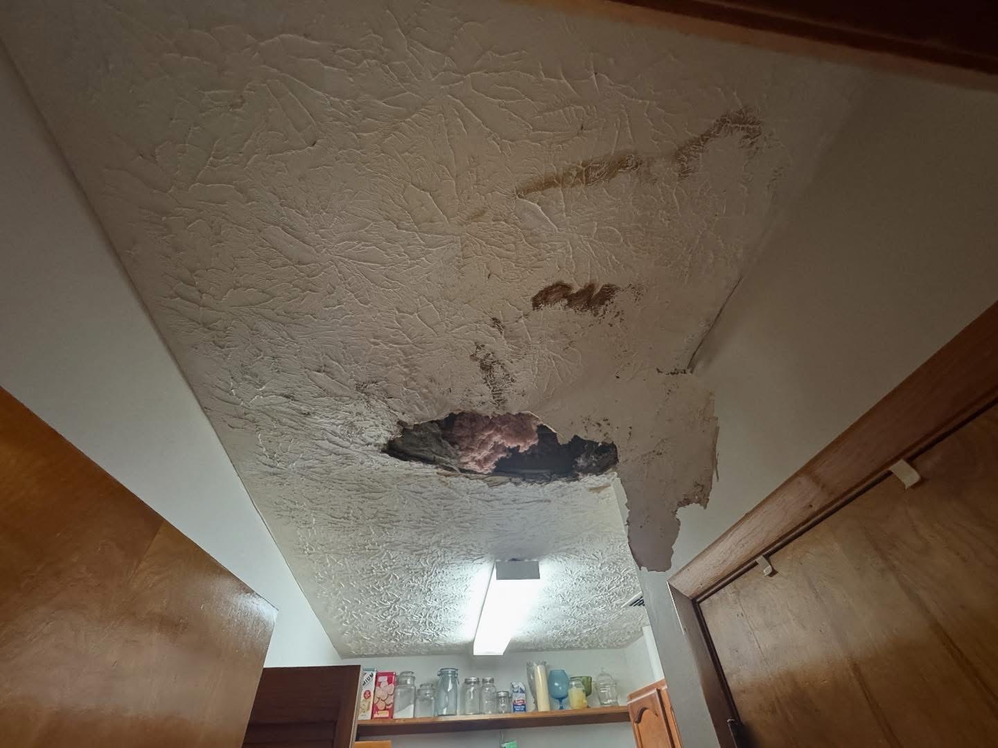 Ceiling and walls saturated from a leaking roof before mitigation